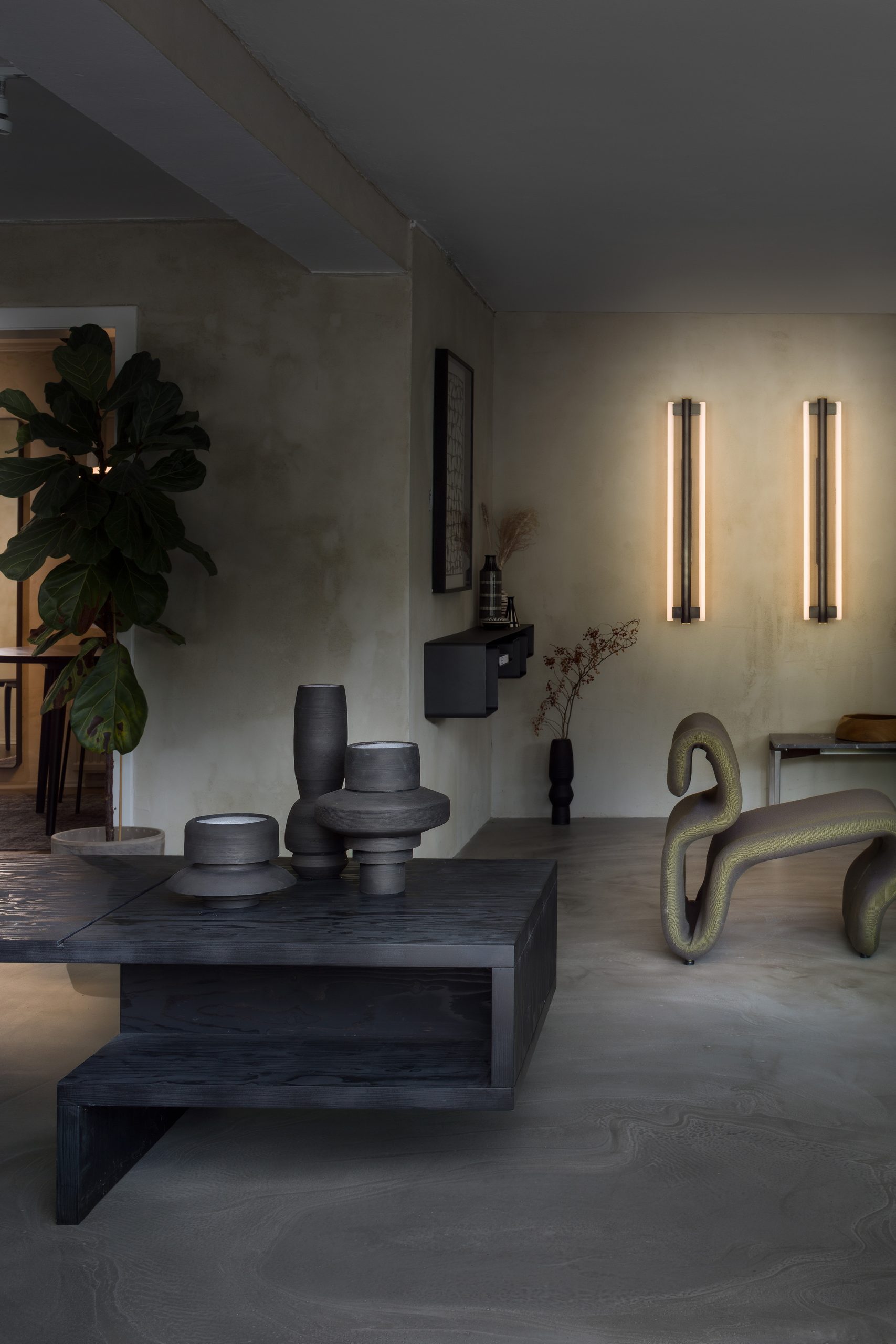 Peam Showroom innen schwarzer Tisch mit Keramik und grünem Vintagesessel